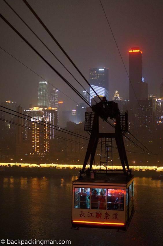 a gondola in the middle of a city at night with lights on it