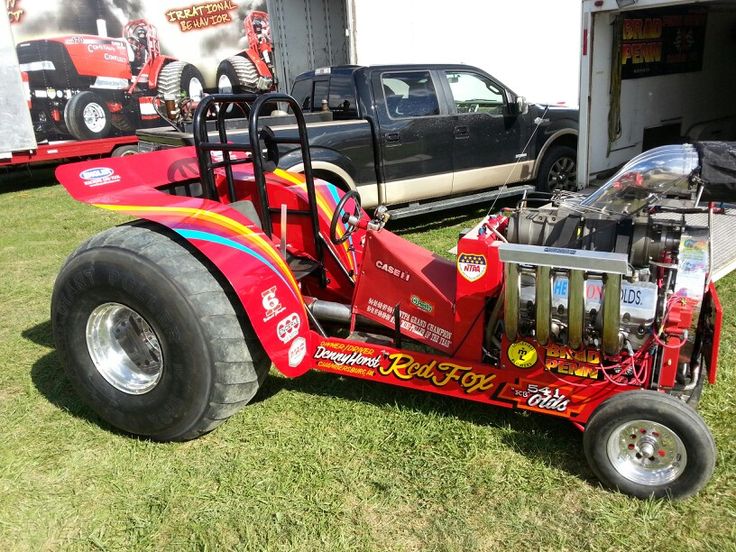 a red race car is parked in the grass