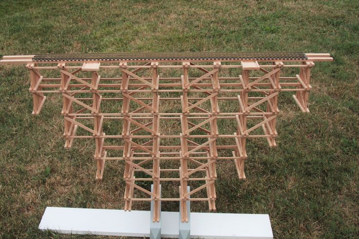 a wooden structure sitting on top of a grass covered field next to a white object