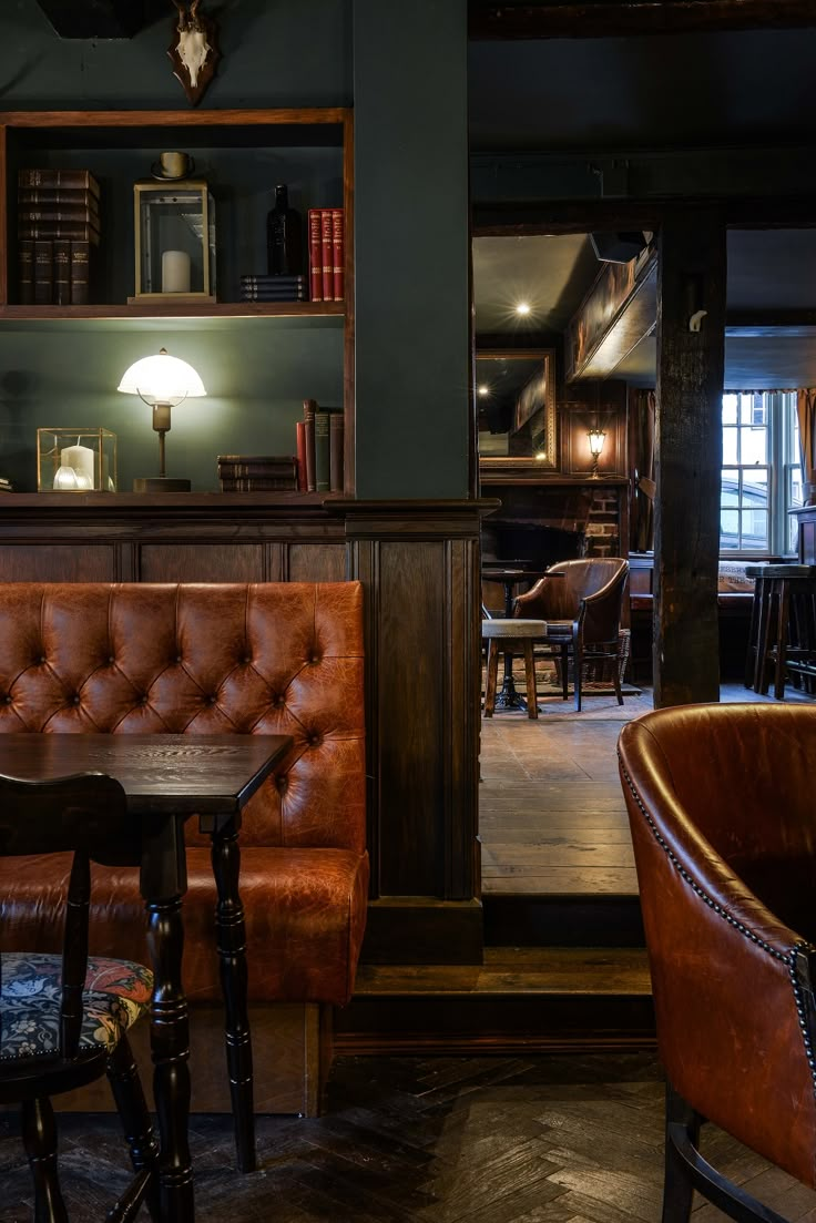 the interior of a bar with leather chairs and tables