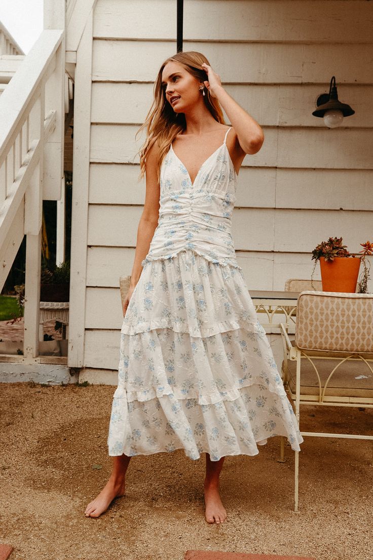 white ruched tiered maxi dress with blue floral print | english floral print dress Affordable Sleeveless Sundress By Urban Outfitters, Ruched Midi Dress With Ruffled Straps For Garden Party, Fitted Tiered Dress For Vacation, Ruched Maxi Sundress For Garden Party, Spring Gatherings Ruched Midi Dress, Flowy Ruched Sundress For Garden Party, Feminine Summer Dresses For Gatherings, Feminine Dresses For Summer Gatherings, Fitted Tiered Sundress For Brunch