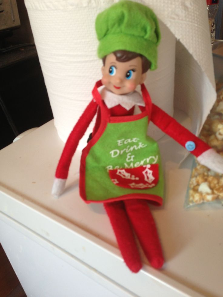 an elf with a green apron and hat is next to a roll of toilet paper