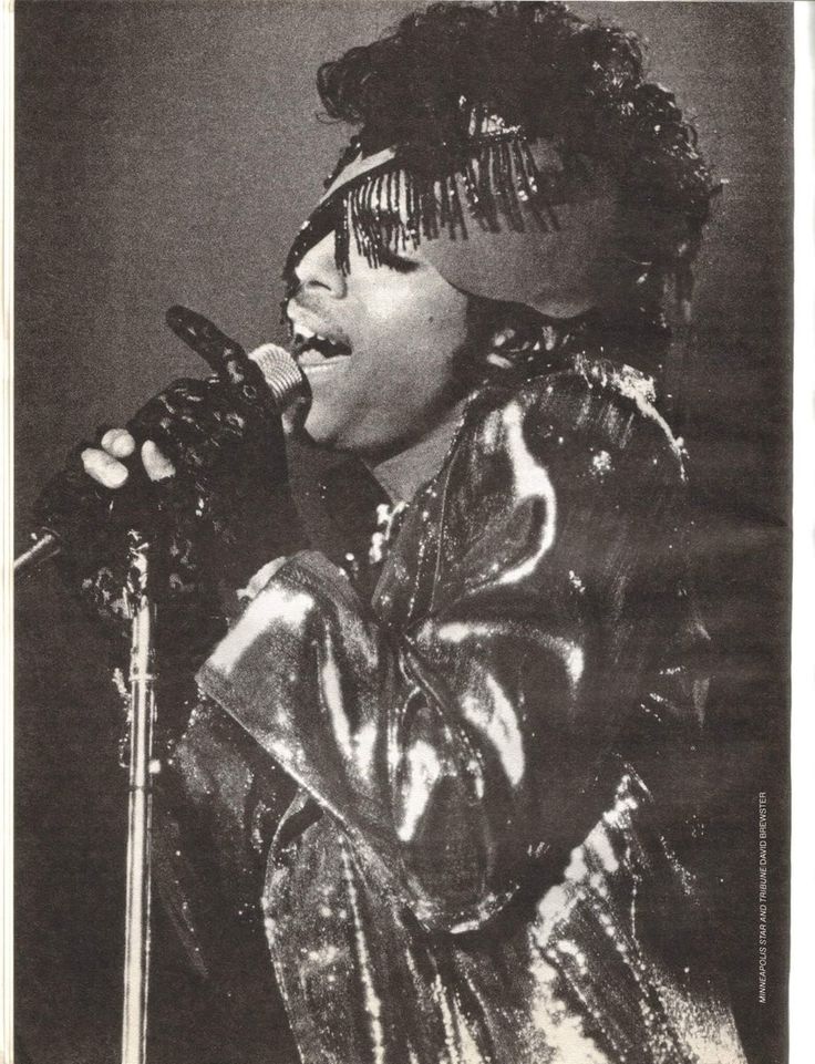 a black and white photo of a woman singing into a microphone