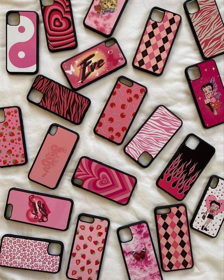 many cell phones are lined up on a white sheet with pink and black designs in them