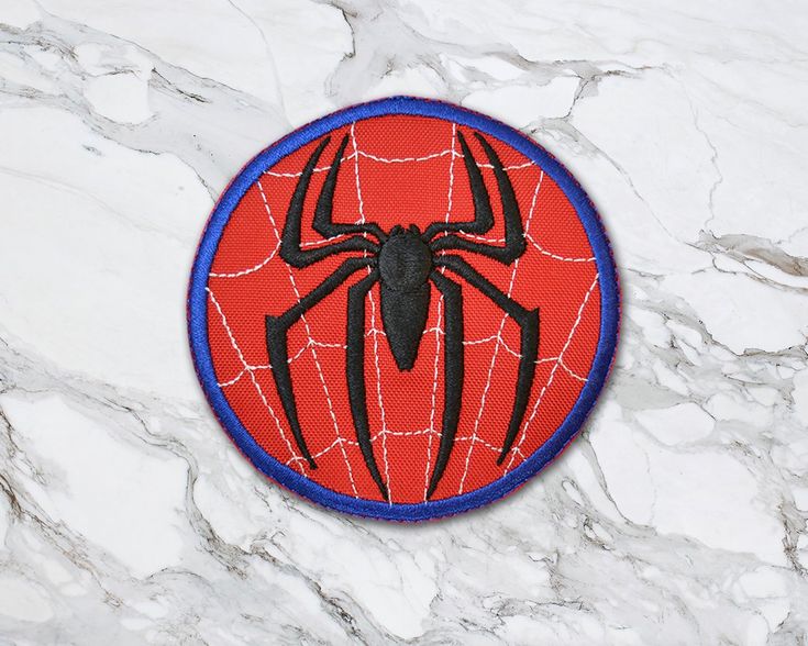 a spider - man patch on a marble surface