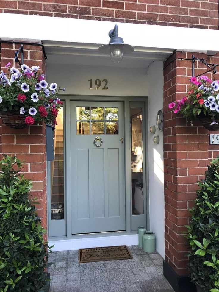 a blue front door with flowers hanging from it's sides and the number 1012