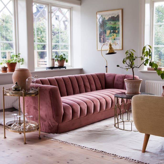 a living room filled with furniture and potted plants