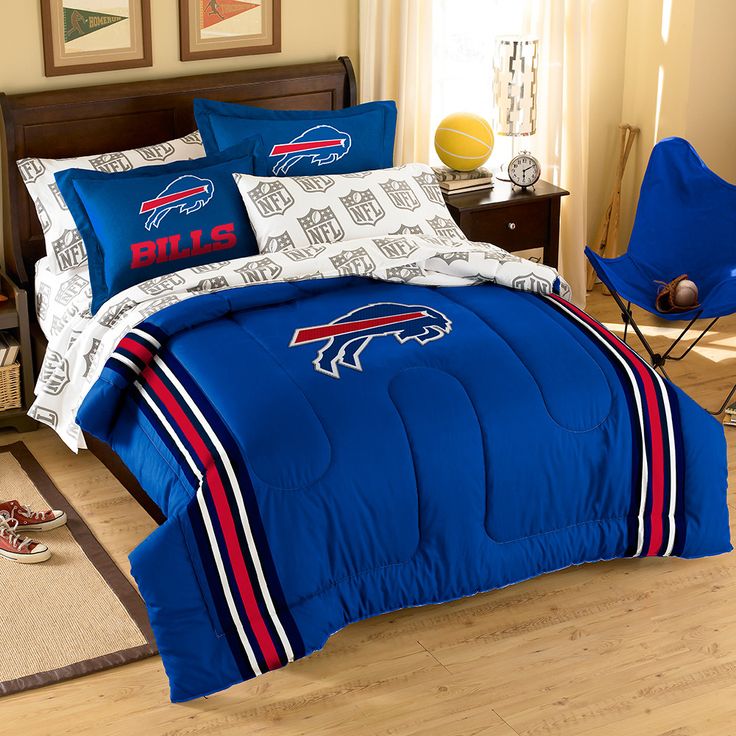 a bed room with a neatly made bed and sports themed comforter sets on it