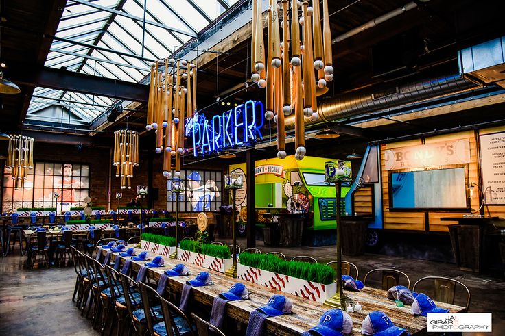 an indoor dining area with tables, chairs and signs hanging from the ceiling above them