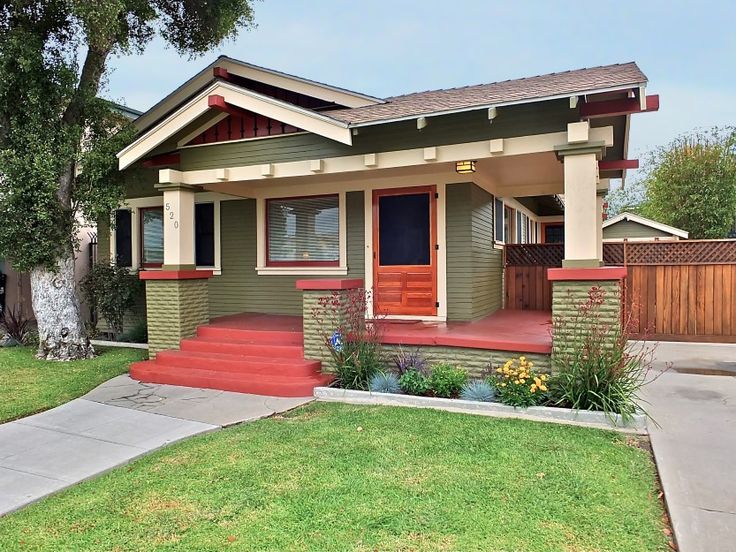 a small house with red steps and green sidings on the front porch is shown