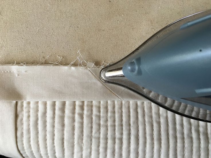 a close up of a hair dryer on top of a piece of fabric with stitches