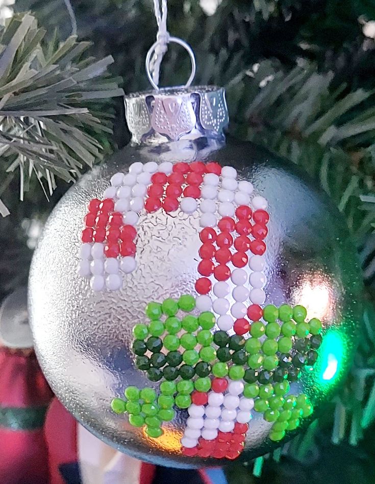 an ornament hanging from a christmas tree decorated with bead work and beads