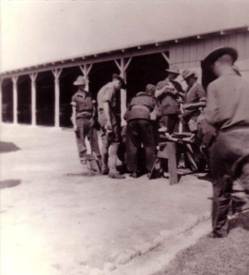 a group of men standing next to each other in front of a building with a bench