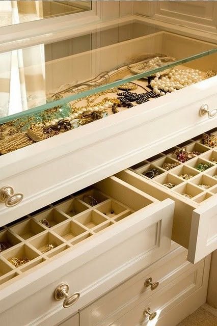 a white dresser with drawers filled with jewelry