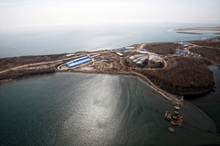 an aerial view of the ocean and some land with buildings on it's sides