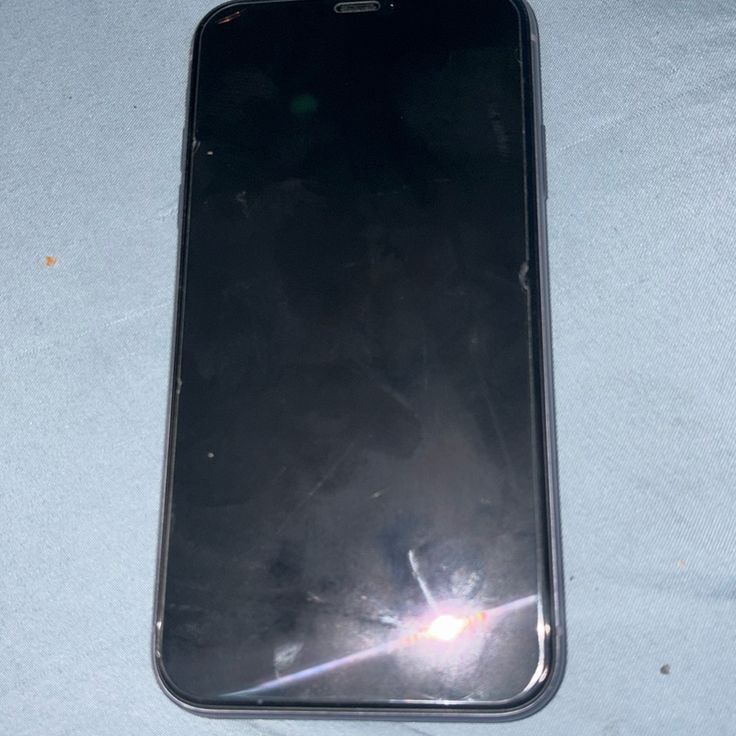 an image of a cell phone laying on the ground with it's screen broken