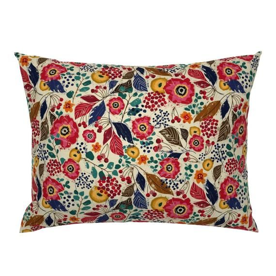 a pillow with colorful flowers and leaves on it