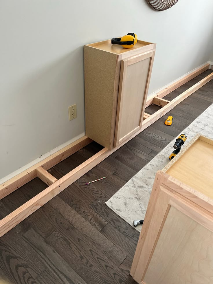 an unfinished cabinet is being built in the corner of a room with wood flooring