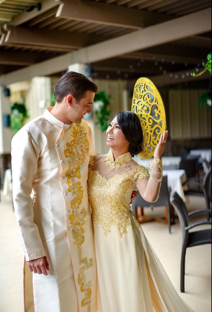 a man and woman standing next to each other holding a yellow frisbee in their hands