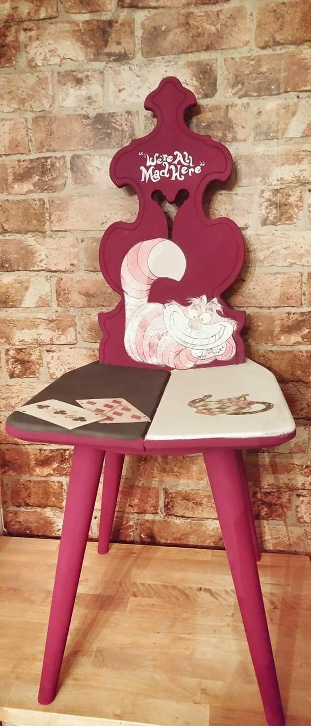 a pink chair sitting on top of a hard wood floor next to a brick wall