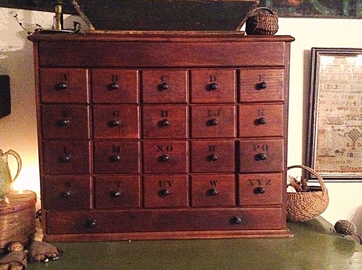 a large wooden dresser sitting next to a wall with pictures on the wall behind it