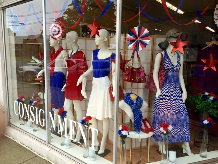 several mannequins dressed in patriotic clothing and hats are displayed behind glass windows