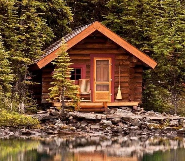 a small log cabin sitting on top of a lake