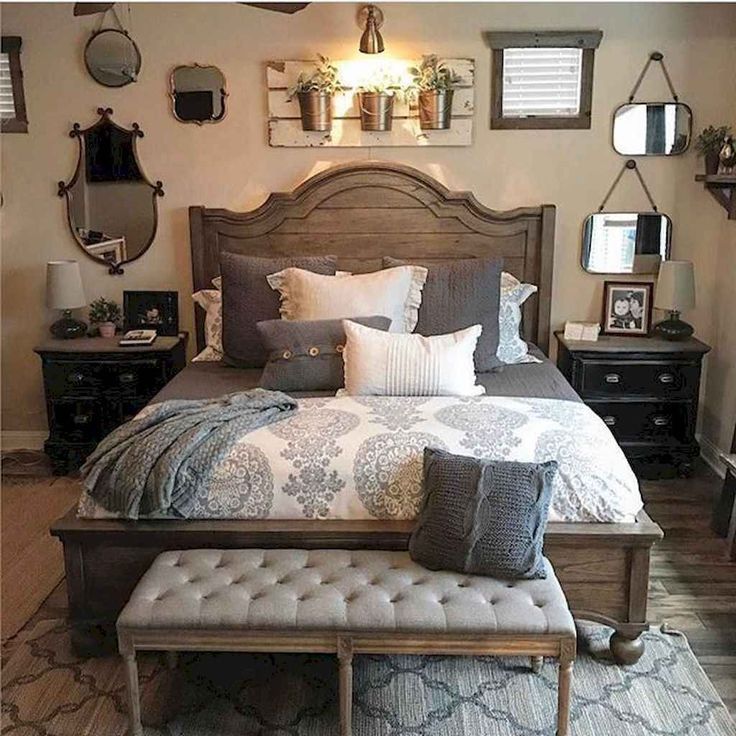 a bedroom with a large bed and lots of pillows on the headboard, along with several other decor items