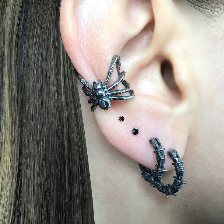 a woman wearing ear piercings with black beads