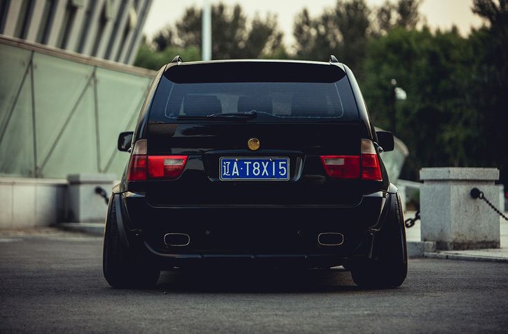 the back end of a black car parked in a parking lot