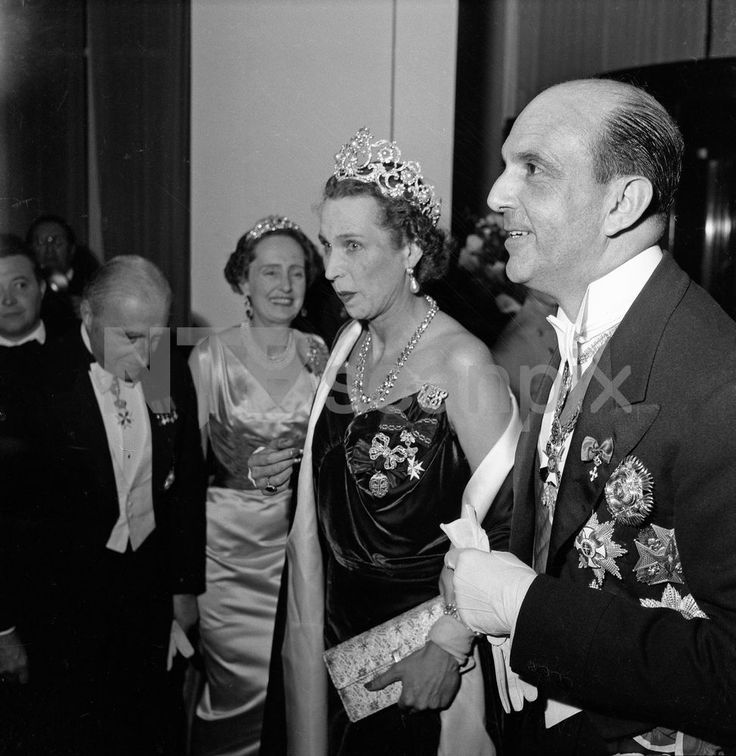 an old black and white photo of two people wearing tiaras