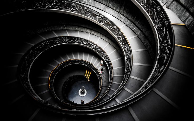 a spiral staircase in black and white with intricate designs