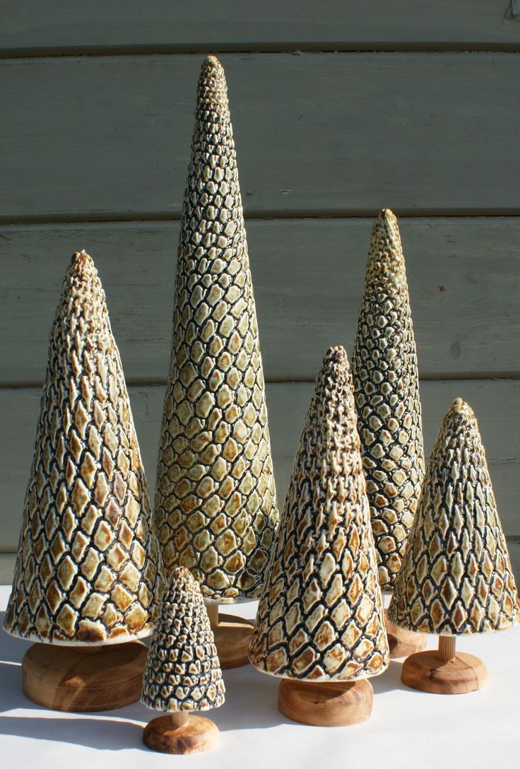 five ceramic pine cones sitting on top of a white table