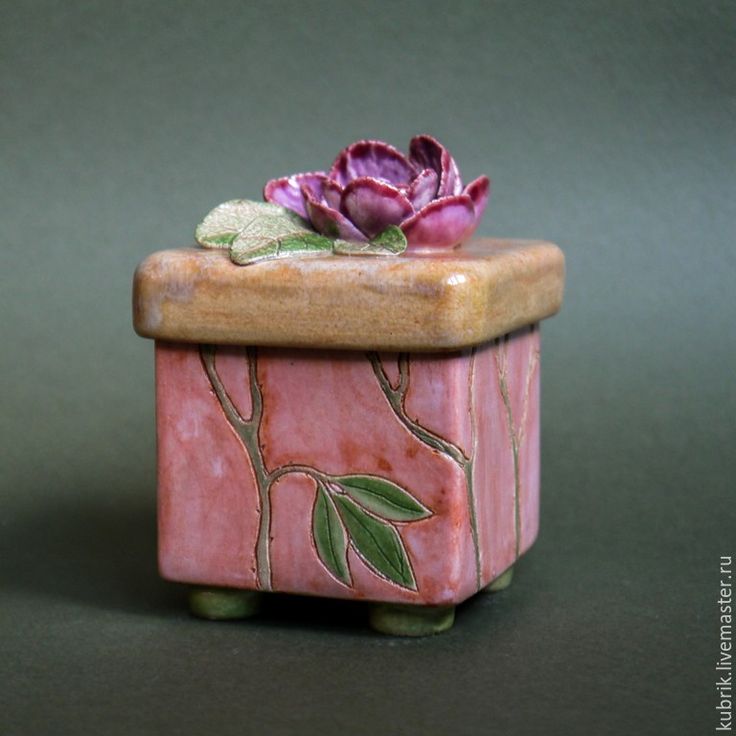 a small ceramic box with a flower in it