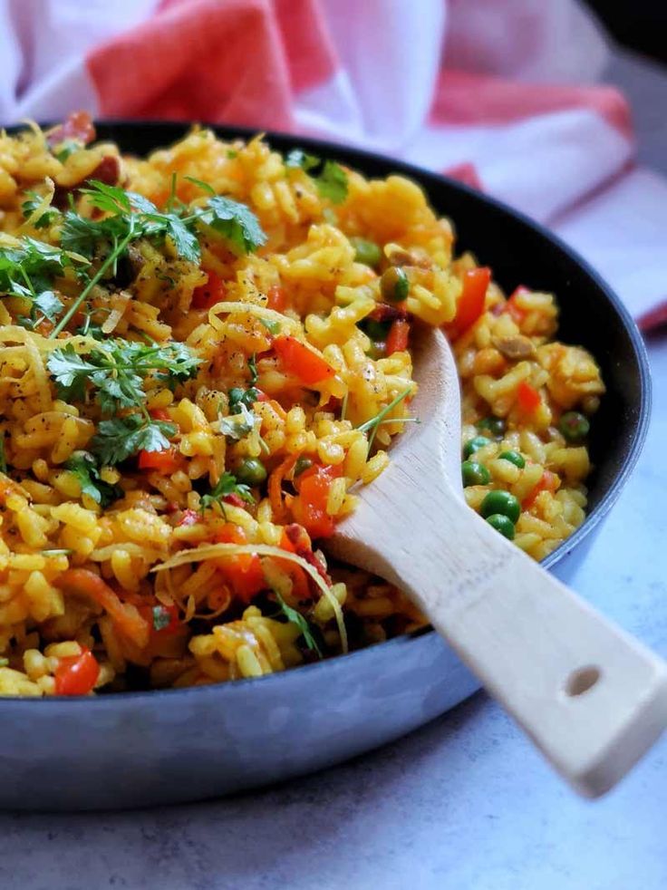 a pan filled with rice and vegetables on top of a table