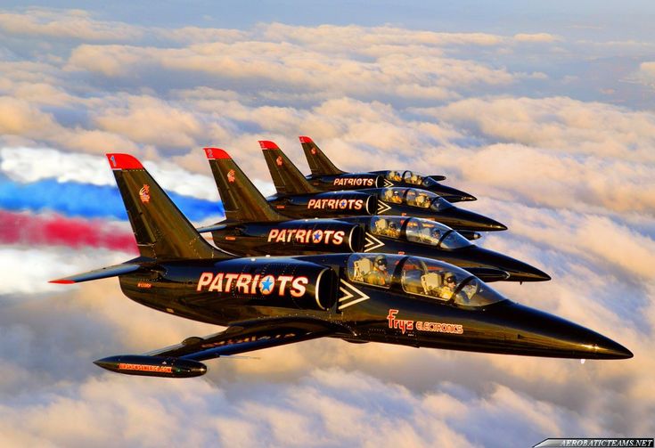 four fighter jets flying in formation above the clouds