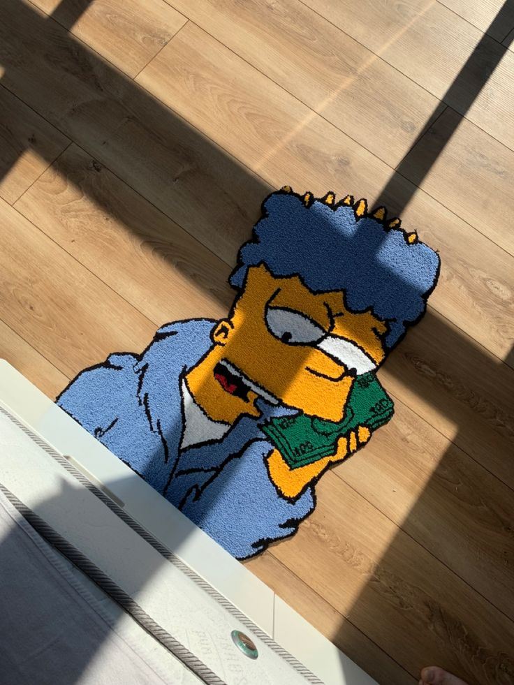 the rug is made to look like homer simpson holding a green object in his hand