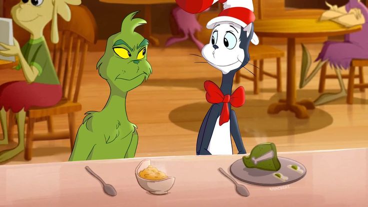 the cat in the hat is looking at another cat sitting at a table with food on it