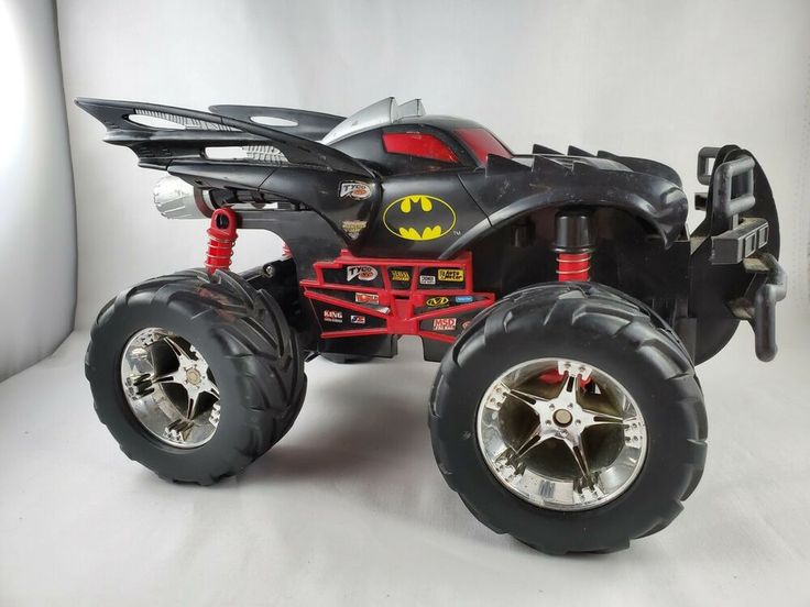 a toy monster truck with batman logo on the front and back wheels, is shown