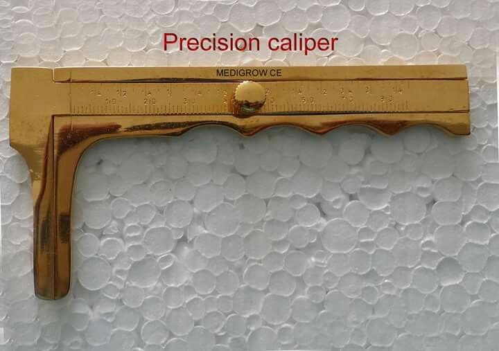 a close up of a metal object on a white surface with the words precision caliper above it