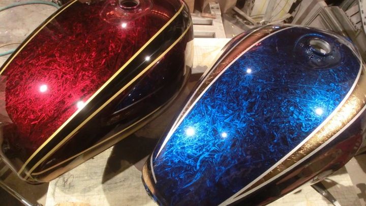 two shiny red and blue cases sitting on top of a wooden table next to each other