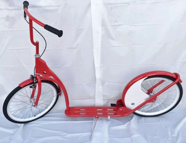 a red scooter sitting on top of a white sheet