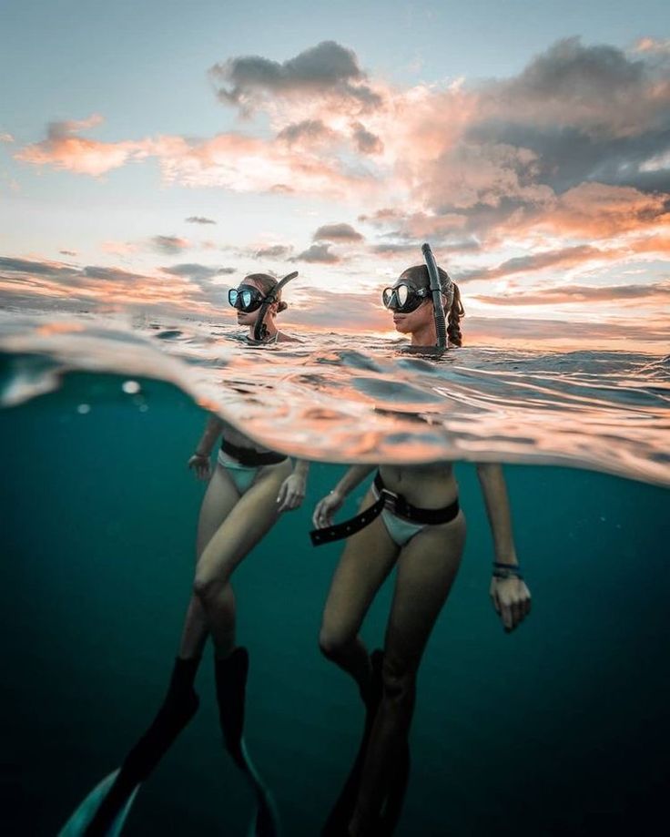 two people are swimming in the ocean with their snorkels and masks on