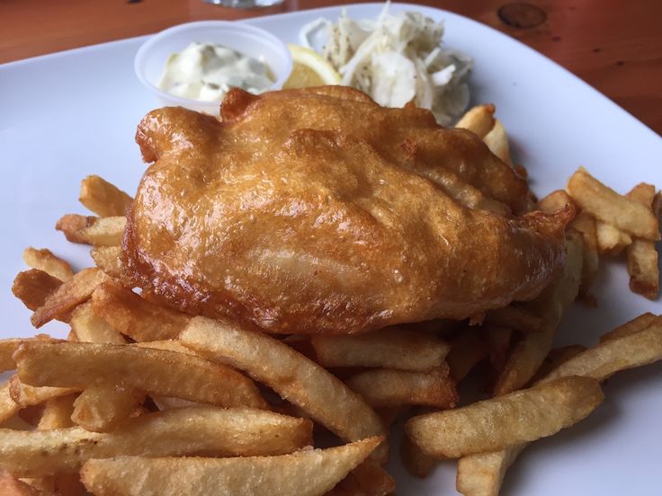 a white plate topped with french fries and coleslaw