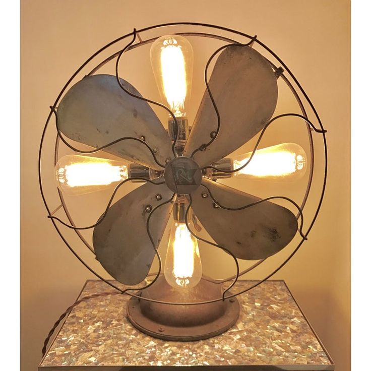 an old fashioned metal fan light on top of a table