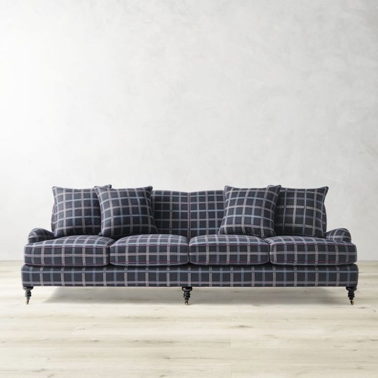 a couch sitting on top of a hard wood floor next to a white wall in an empty room