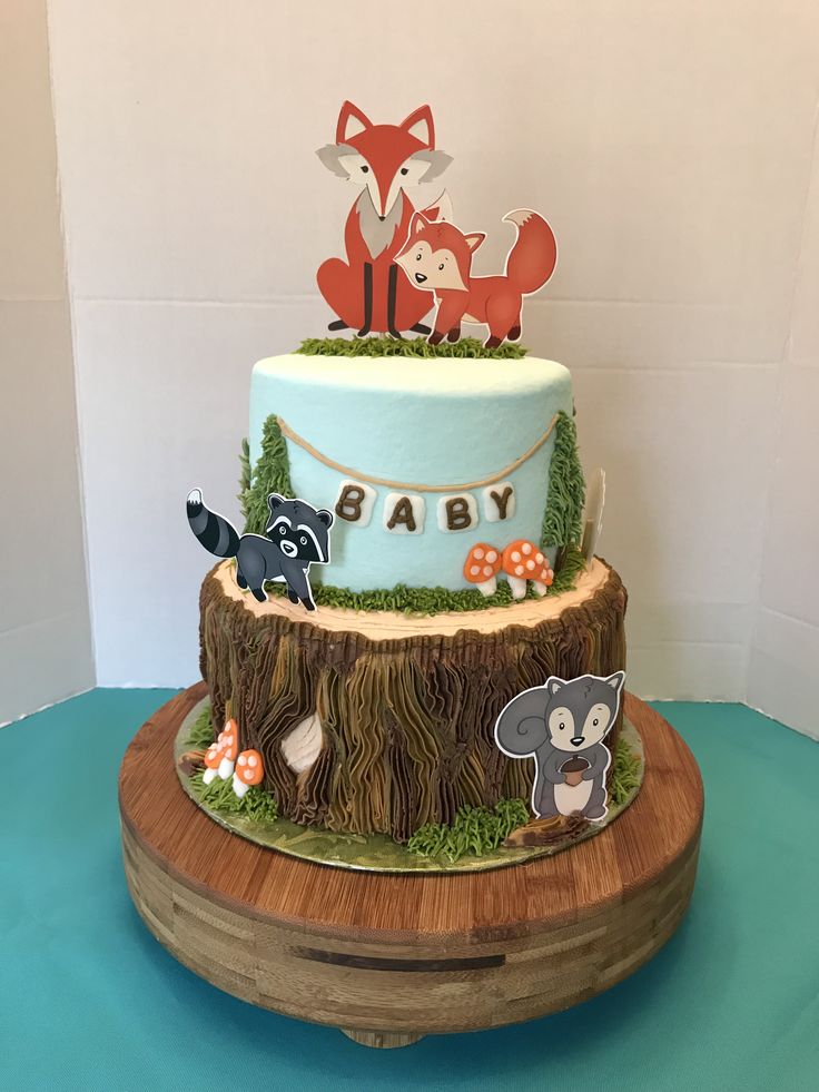 a baby shower cake with woodland animals on it