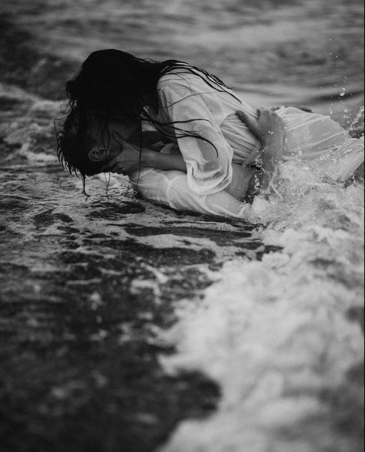 a woman laying on her stomach in the water