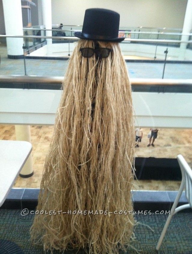 a long blonde wig with a top hat and bow tie in an airport terminal area