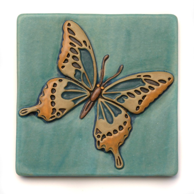 a ceramic tile with a butterfly on it